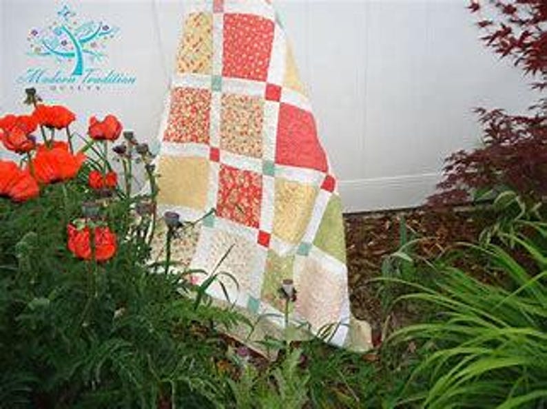 May include: A patchwork quilt featuring a grid of square fabric blocks in shades of coral, yellow, and light green, separated by white sashing and small red cornerstones. The quilt displays a repeating floral pattern across its various fabric sections.