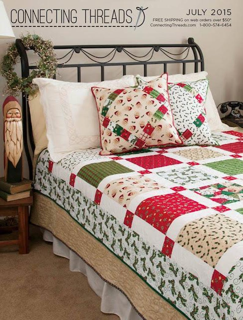 May include: A bed featuring a black metal headboard, a patchwork quilt with red, green, and cream holiday-themed fabric squares, and two decorative pillows. One pillow displays a Santa Claus pattern, while the other has a green and white holly print.
