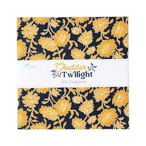 May include: A stack of fabric squares with a floral pattern in yellow and navy blue. The fabric is wrapped with a white band that reads "Cheddar at Twilight" and "RBD Designers". The Riley Blake logo is also visible.