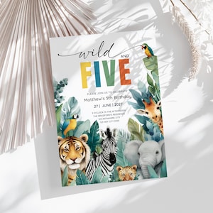Può includere: Un invito di compleanno con le parole "wild and FIVE" in lettere colorate. L'invito presenta illustrazioni di una tigre, zebra, leopardo, elefante, giraffa e pappagallo, circondati da fogliame tropicale. Il testo recita "Please join us to celebrate Matthew's 5th Birthday".