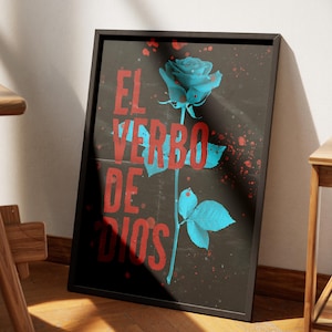 May include: Framed art print featuring a stylized blue rose on a dark background with red splatter accents. The text "EL VERBO DE DIOS" is in red. The artwork is leaning against a wall next to a wooden chair.