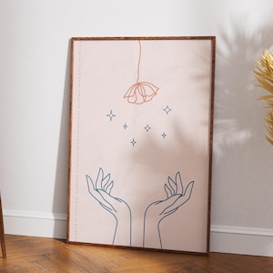 May include: A framed art print featuring a minimalist line drawing. The artwork depicts two hands reaching upwards, with a flower and stars above. The color palette includes shades of pink, brown, and blue, creating a serene and artistic aesthetic.