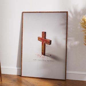 May include: A framed print featuring a wooden cross with red accents and blood-like splatters. The text "FOR VUESTROS PECADOS" is at the bottom. The artwork is set against a white background, with a wooden frame.
