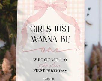 Peut inclure: Un panneau blanc sur un chevalet en bois avec le texte "GIRLS JUST WANNA BE one" en noir et rose. En dessous, "WELCOME TO Amelia's FIRST BIRTHDAY" en écriture rose. Un nœud et un ruban roses ornent le haut.