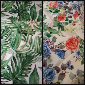 May include: Two fabric swatches with floral patterns. The first swatch features a green tropical leaf design on a white background. The second swatch features a white background with a variety of colourful flowers, including red, blue, and pink.