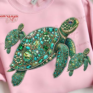 May include: Pink sweatshirt featuring a detailed, jewel-toned sea turtle design with two smaller turtles. The turtles are in shades of teal, green, and gold, with pearl accents. The text "EASY DOWNLOAD Crafts" is visible on the left side.