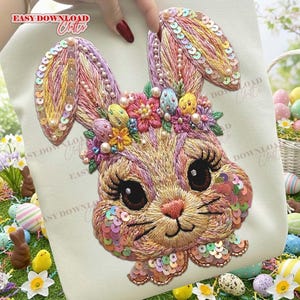 Puede incluir: Diseño bordado de conejito de Pascua con lentejuelas, perlas y detalles florales coloridos. El conejito tiene ojos grandes y largas pestañas. El diseño está sobre una tela color crema, con el texto "EASY DOWNLOAD Crafts" visible.