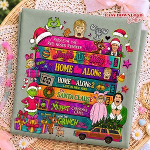 Puede incluir: Una tela verde salvia con una pila de cintas VHS coloridas con t&iacute;tulos de pel&iacute;culas navide&ntilde;as como Rudolph the Red Nosed Reindeer, Jingle All the Way, Home Alone, Home Alone 2, The Santa Clause, The Muppet Christmas Carol y How the Grinch Stole Christmas.