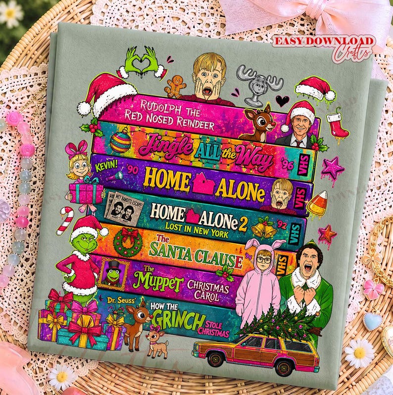 Puede incluir: Una tela verde salvia con una pila de cintas VHS coloridas con t&iacute;tulos de pel&iacute;culas navide&ntilde;as como Rudolph the Red Nosed Reindeer, Jingle All the Way, Home Alone, Home Alone 2, The Santa Clause, The Muppet Christmas Carol y How the Grinch Stole Christmas.