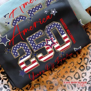 May include: Black sweatshirt with the text "America 250 Years Of Freedom" in red script. The "250" is designed with the American flag pattern. Additional stars in blue and white complete the patriotic design.