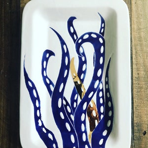 May include: A white ceramic rectangular serving dish with a blue and white octopus design. The octopus tentacles are outlined in white and have blue dots.