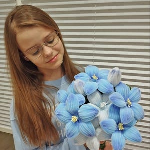 Op de afbeelding: Een set van drie keramische nestkommen in blauwe, groene en witte tinten. De kommen hebben een gespikkelde glazuur en een eenvoudig, modern ontwerp. De grootste kom heeft een diameter van ongeveer 15 cm.