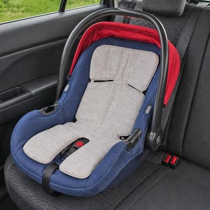 Pode incluir: Cadeira auto azul e cinza para bebé com capota vermelha, presa no banco traseiro de um carro. O assento tem uma inserção acolchoada cinza e uma alça preta. Projetado para a segurança infantil durante as viagens.