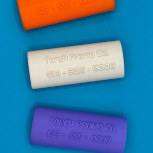 May include: Three silicone phone grips in orange, white, and purple. Each grip has the text "Torch Promo Co. 123-555-0000" embossed on it.