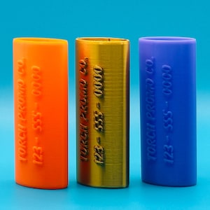 May include: Three cylindrical containers with different colored caps. The orange container has the text "Torch Premium Co. 123-555-0000" printed on it. The gold container has the text "Torch Premium Co. 123-555-0000" printed on it. The blue container has the text "Torch Premium Co. 123-555-0000" printed on it.