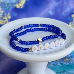 Blue “Resist” Beaded Stretch Bracelet: Glass Seed Beads, Gold Accents