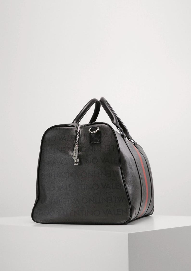 May include: Black duffel bag with a red stripe and the brand name printed all over. The bag has two handles and a zipper closure. The bag is made of a durable material and is suitable for travel.