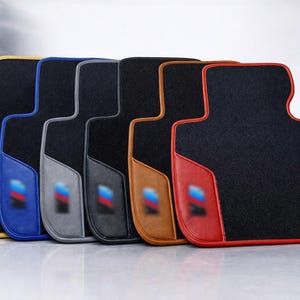 Tappetini per auto BMW con logo M, in moquette nera con finiture in pelle rossa.