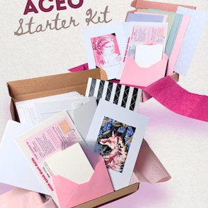 May include: An ACEO Starter Kit containing a collection of art cards, envelopes, and instructional guides. The kit includes white cardstock, pink envelopes, and printed cards featuring a classical bust and a fox illustration, all housed in a cardboard box.