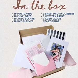 May include: A cardboard box containing 10 postcards, 10 envelopes, 10 ACEO blanks, 10 PVC sleeves, 1 sheet of photo corners, 1 mystery print, and 1 ACEO quick start guide. The text In the box is printed above the items in a brown script font.