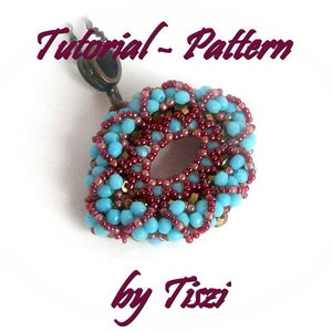 May include: A turquoise and burgundy beaded pendant with a gold accent, hanging from a brown cord. The pendant is in the shape of a circle with a hole in the center. The text "Tutorial - Pattern by Tizzi" is written in purple above the pendant.