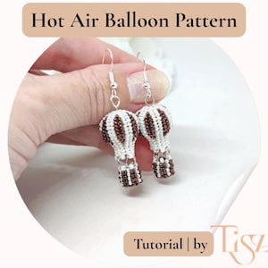 Può includere: Orecchini fatti a mano con un design a mongolfiera. I palloni sono bianchi e marroni, con ganci argentati. Il testo "Hot Air Balloon Pattern" e "Tutorial | by Tiszi" sono inclusi. Un accessorio unico.