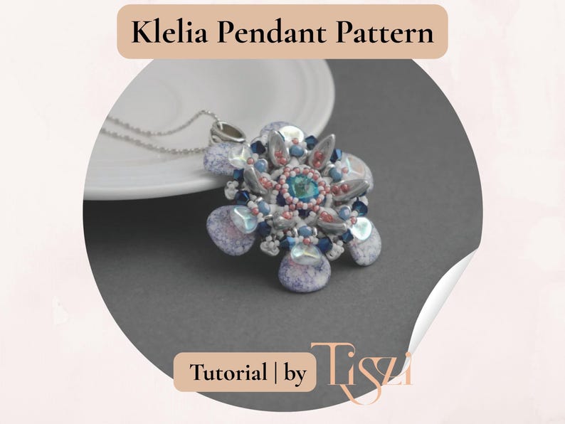 May include: A floral pendant necklace with a silver chain. The pendant features a central turquoise stone surrounded by pink, blue, and silver beads. The text "Klelia Pendant Pattern" is at the top.