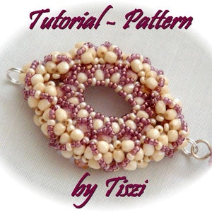 May include: A close-up of a beaded jewelry pattern tutorial by Tizzi. The pattern is made with small, white and purple beads, and is shaped like a flower.