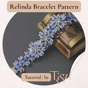 K&ouml;nnte beinhalten: Ein Perlenarmband mit einem floralen Design in Blau- und Wei&szlig;t&ouml;nen, das auf einer dekorativen Holzkiste liegt. Das Armband ist der Blickfang und zeigt aufwendige Perlenarbeiten. Der Text oben lautet "Relinda Bracelet Pattern".