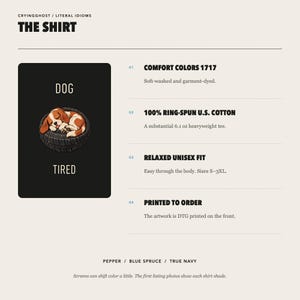 Op de afbeelding: Een zwart t-shirtontwerp met een bruine en witte puppy die in een zwarte band slaapt, met de tekst DOG erboven en TIRED eronder. Productdetails vermelden Comfort Colors 1717, 100% ringgesponnen katoen, 173g gewicht en een unisex pasvorm.