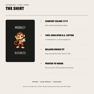 May include: A black t-shirt graphic featuring a cartoon monkey holding a yellow telephone and a white notepad with the text MONKEY BUSINESS. The product details list Comfort Colors 1717, 100% ring-spun U.S. cotton, 6.1 oz weight, and DTG printing.