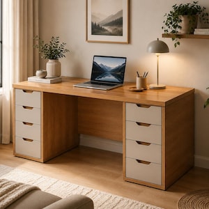 May include: A wooden desk with a light brown finish featuring two columns of four drawers each. The drawers have light gray fronts and integrated horizontal handles. A laptop is placed on the center of the desktop surface.