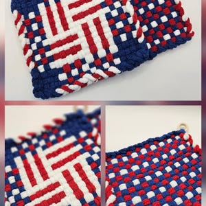 Puede incluir: Salvamanteles tejidos en rojo, blanco y azul. Los salvamanteles tienen un dise&ntilde;o tejido con un borde azul y un anillo de madera para colgar. El dise&ntilde;o recuerda a una bandera.