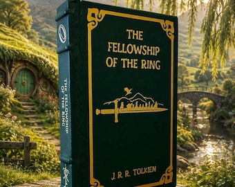 May include: A hardback book titled The Fellowship of the Ring by J.R.R. Tolkien with a dark green cover and gold lettering. The front cover features a gold border, a sword graphic, and a silhouette of figures. The spine includes a gold ring icon.