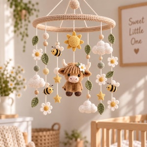 May include: A crochet baby mobile featuring a central brown highland cow, yellow sun, white clouds, yellow stars, green leaves, white daisies, and striped bees hanging from a circular frame. The elements are crafted with yarn in various colors.
