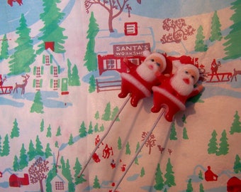 two tiny wee santas on a wire