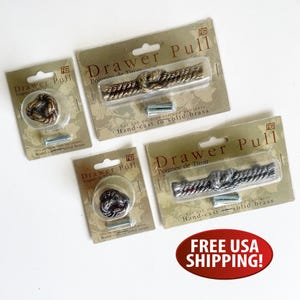 May include: Four hand-cast solid brass drawer pulls in nautical rope knot designs, packaged on individual cardboard backing cards labelled Drawer Pull. Two pulls are round knobs and two are elongated handles, featuring metallic gold and silver finishes.