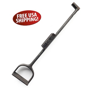 May include: A vintage, dark metal tool with a handle and a rectangular section marked "WEBSTER". The tool has a D-shaped handle at one end and a bent, hook-like shape at the other. The tool is likely used for a specific task.