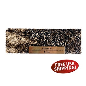 May include: A rectangular Slimbrick sample with a textured surface, featuring a mix of black and tan tones. The brick has a small wooden label with the text "SLIMBRICK®" and details about the ash used. The brick is coated with Mount St. Helen's ash.