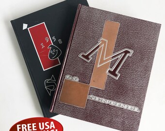 May include: Two vintage yearbooks. The first is black with white text that says "1958" and a cartoon ghost. The second is maroon with a silver "M" and the text "Go Sentinel".