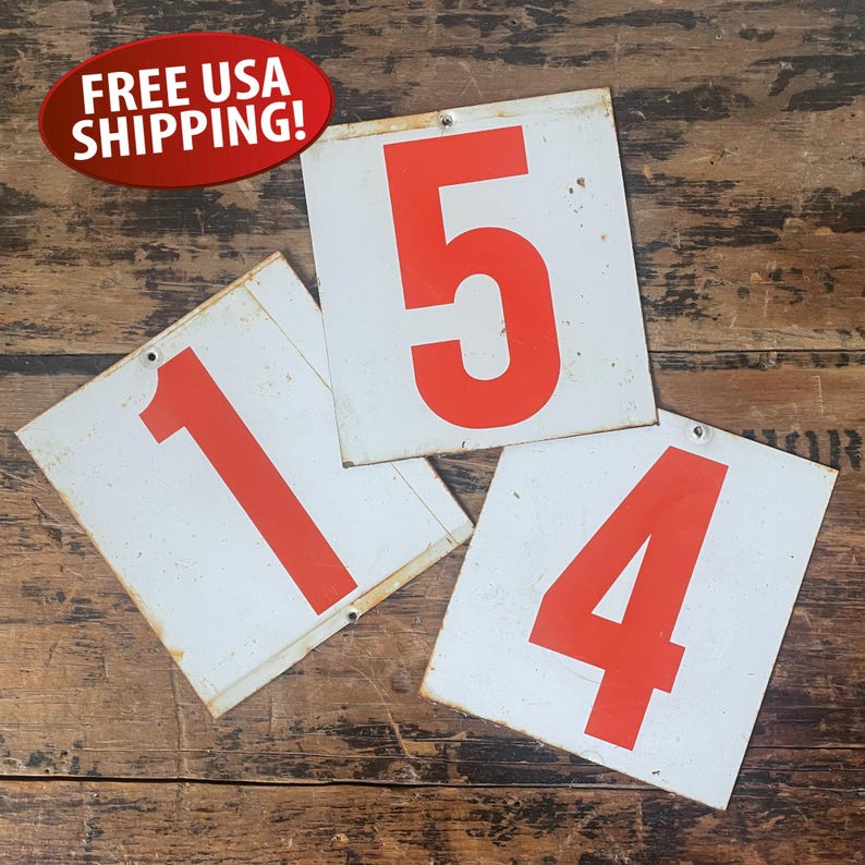 May include: Three vintage white metal signs with large red numbers 1, 4, and 5. The signs have a distressed appearance, with visible wear and tear. Each sign has a hole at the top for hanging. The signs are likely used for a shop or business.