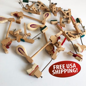 May include: A collection of wooden piano key parts, including hammers, dampers, and other components. The parts are scattered on a white surface.  FREE USA SHIPPING! is written in red on a white oval.