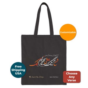 Puede incluir: Bolso tote negro con un diseño en escritura urdu. El bolso tiene un asa larga y presenta el texto "Inspired By Heritage" y "Your Text Here". Una pegatina redonda naranja dice "Personalizable". Un círculo azul dice "Envío gratuito a EE. UU.".