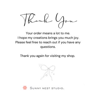Pu&ograve; includere: Una carta bianca con le parole "Thank You" in elegante scrittura. La carta include un messaggio di gratitudine per l'ordine e un invito a contattare per domande. Sono presenti anche un'illustrazione di fiocco e il nome del negozio "SUNNY NEST STUDIO".