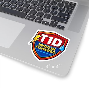 May include: A sticker featuring the text "T1D INSULIN POWERED" in a shield design. The shield is red, blue, and yellow with a lightning bolt and a water droplet. The sticker measures approximately 10 cm by 10 cm.