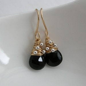 May include: Gold wire wrapped earrings with black onyx teardrop stones and silver beads.