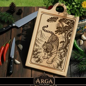 Peut inclure: Planche à découper rectangulaire en bois avec une poignée, ornée d'une gravure au laser d'un tigre dans un paysage naturel. Des couteaux de cuisine, des piments rouges et des gousses d'ail sont disposés autour.