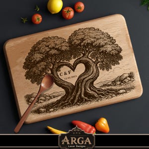 Puede incluir: Tabla de cortar de madera con un diseño de árbol en forma de corazón, grabada con las iniciales "C & F" y la fecha "12.05.2023". Una cuchara de madera descansa sobre la tabla. Verduras frescas rodean la tabla.
