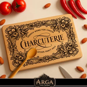 May include: A wooden charcuterie board with the words "CHARCUTERIE" and "FRENCH WORD FOR CHEESE" in black script. The board is surrounded by an ornate floral design. A wooden spoon and a knife are on the board. Red tomatoes, peppers, and almonds are scattered around the board.