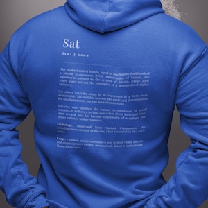 Könnte beinhalten: Ein königsblauer Kapuzenpullover mit dem Wort "Sat" und einer Definition auf der Rückseite. Der Hoodie hat eine Kapuze und eine Vordertasche. Der Text ist weiß. Das Kleidungsstück ist aus weichem Material.